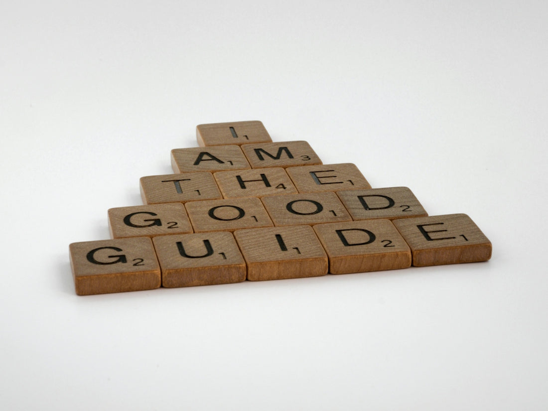 a wooden scrabble with words that read i am the good guide