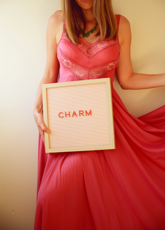A woman holds a sign that says charm.