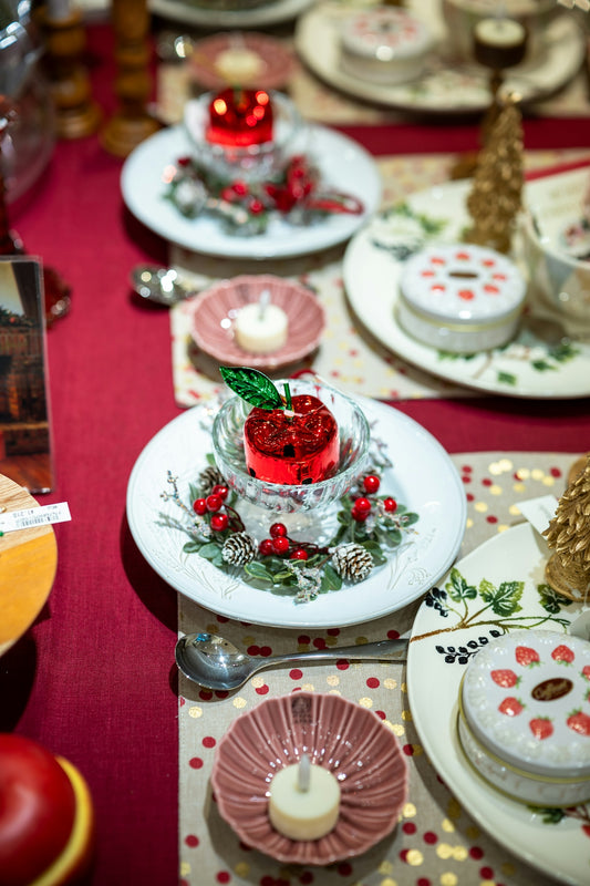 Festive table setting with candles and holiday decorations.